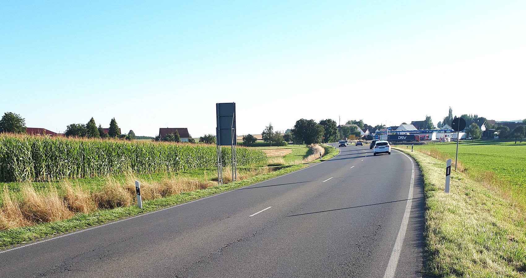 Das Foto zeigt die B 30 mit Blick in Richtung Enzisreute. Rechts und links sind Wiesen bzw. ein Feld zu sehen. neben der Straße 