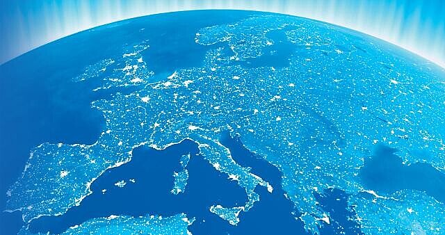 Europäischer Kontinent aus dem All bei Nacht fotografiert, dabei ist der Kontinent hellblau eingefärbt und die Hauptstädte und größere Städte leuchten gelb. 