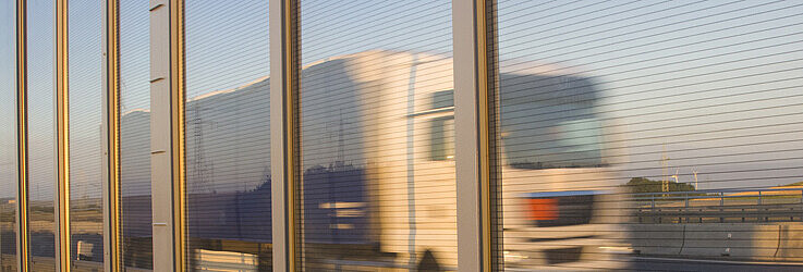 Bild zeigt Lastwagen hinter Lärmschutzwand