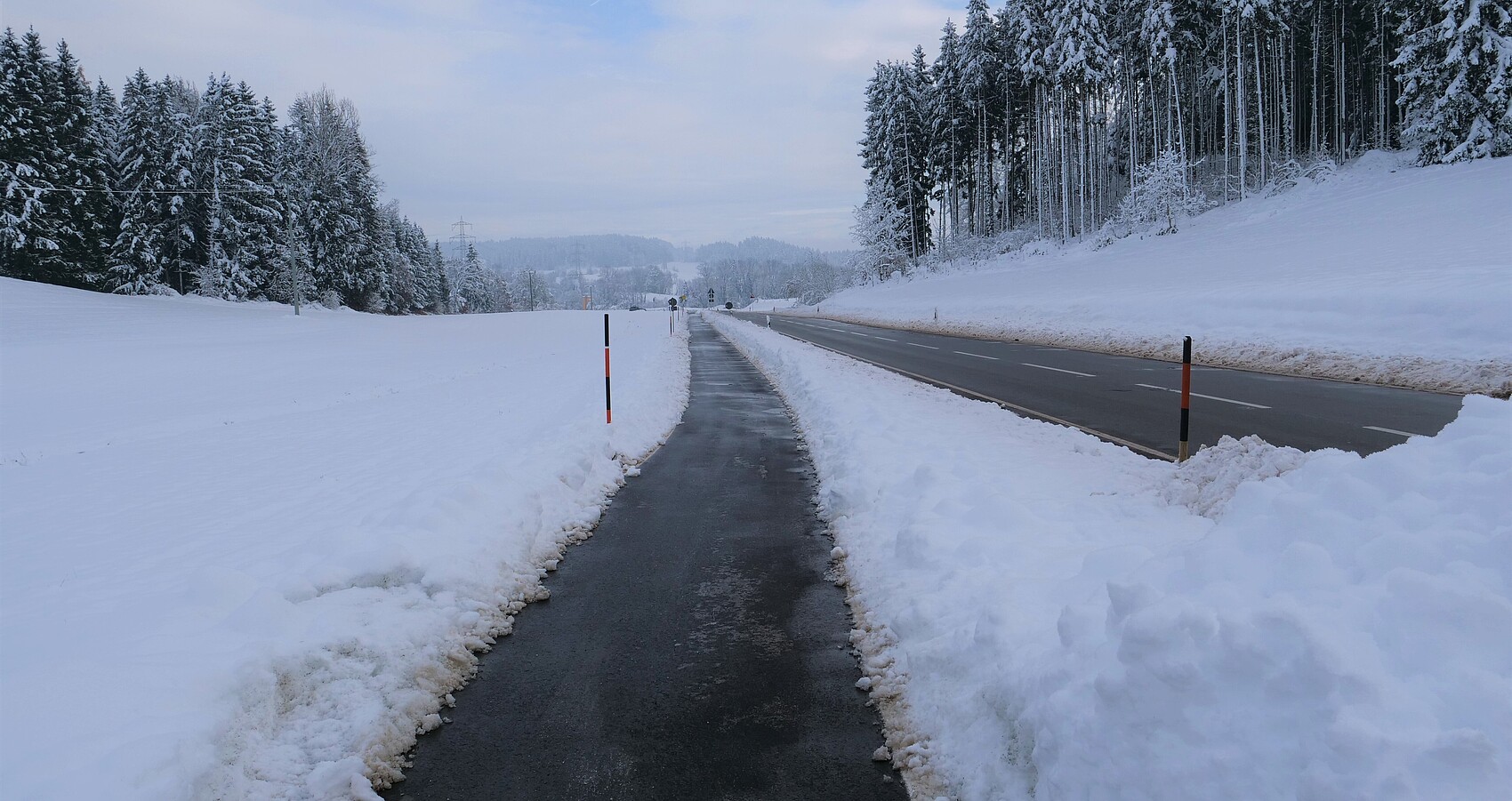 Das Foto zeigt den neuen Radweg entlang der L 335 zwischen Grünkraut und Sigmarshofen umgeben von einer winterlichen Landschaft