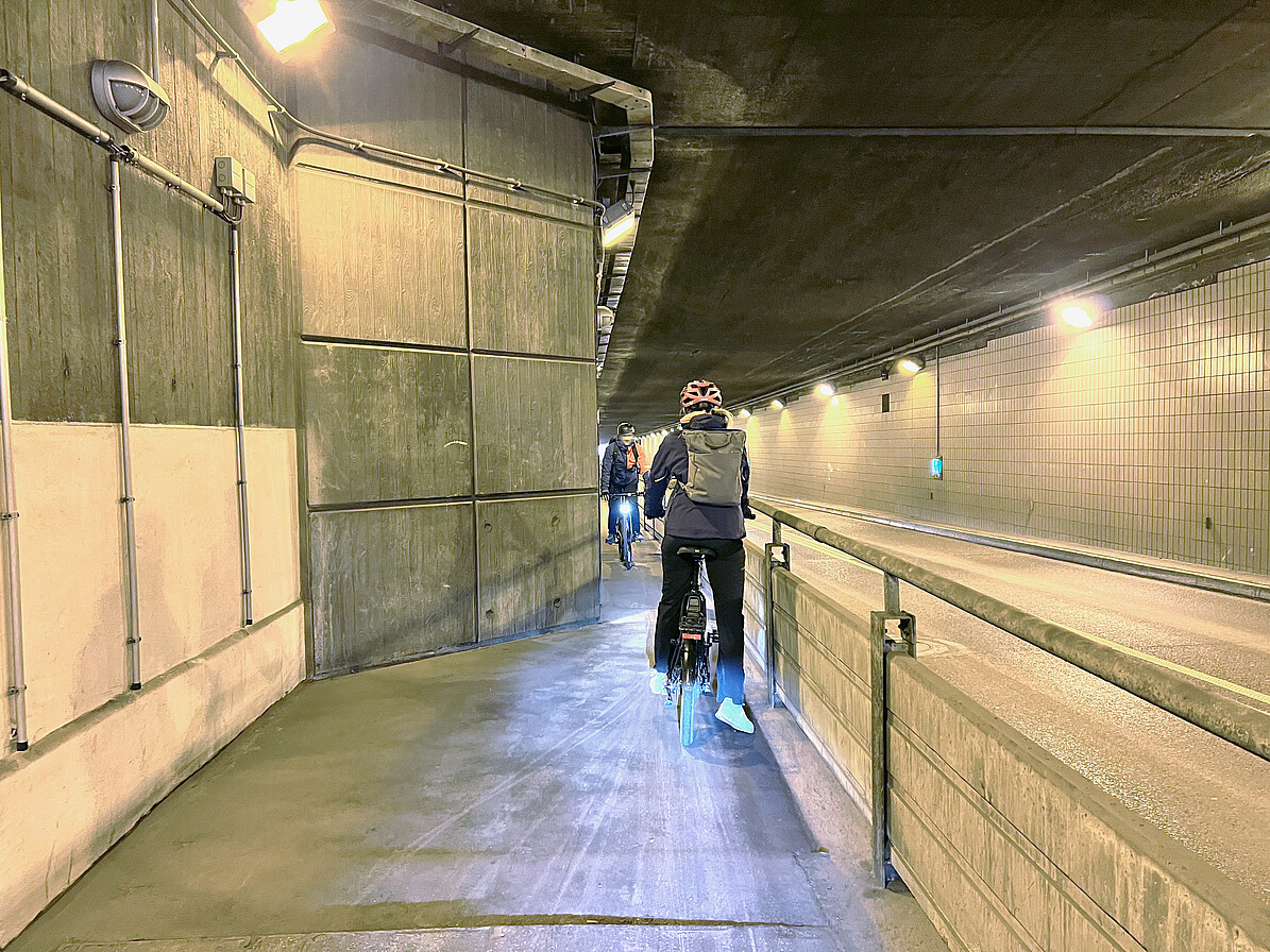 Flughafentunnel mit zwei entgegenkommenden Fahrradfahrern