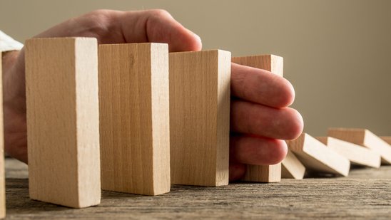 Hand hält Dominosteine auf