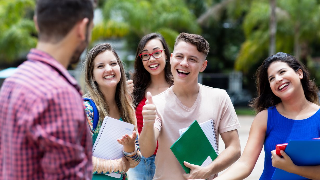 Vier Prüflinge freuen sich mit ihrem Lehrer gemeinsam über die bestandene Abschlussprüfung