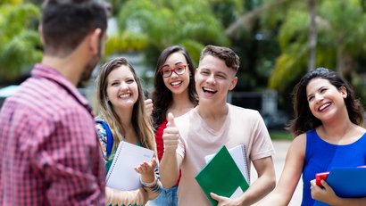 Vier Prüflinge freuen sich mit ihrem Lehrer gemeinsam über die bestandene Abschlussprüfung