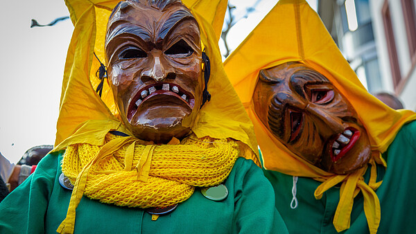 Zwei Menschen mit traditionellen Faschingsmasken
