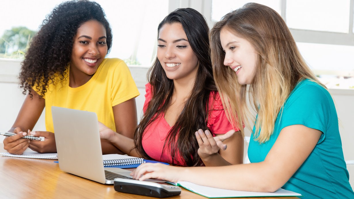 Drei Lehrerinnen sitzen am Tisch und besprechen Unterlagen