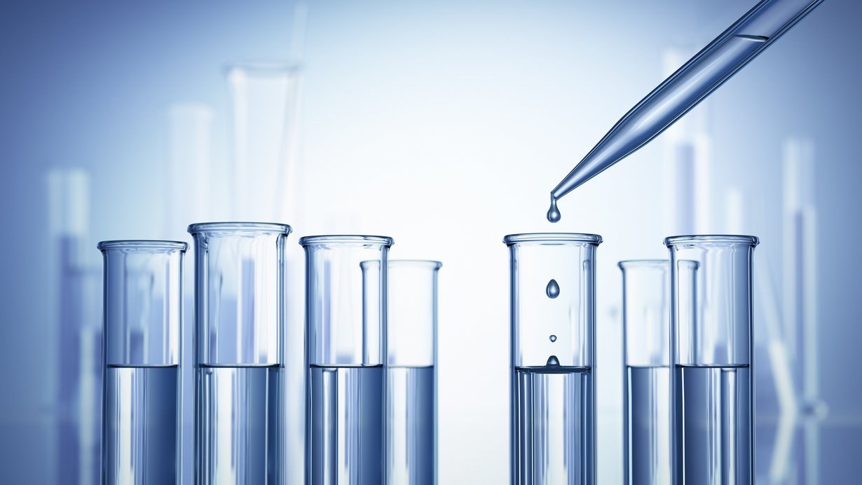 Pipette tröpfelt Flüssigkeit in ein Reagenzglas