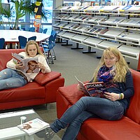 Bibliothek/Mediothek im BSZ Biberach: 2 junge Frauen lesen in der Zeitschriftenecke