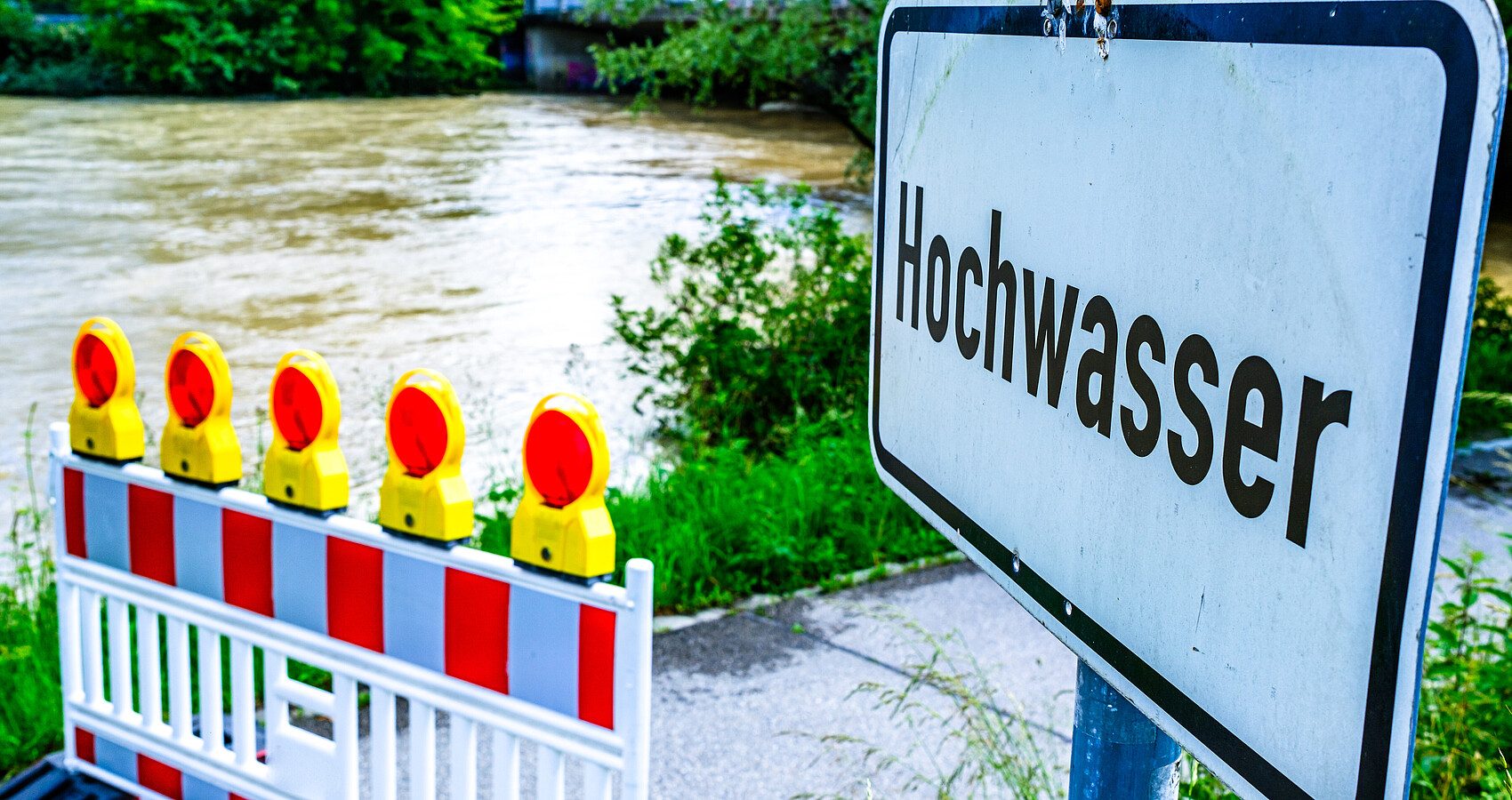 Bild zeigt Absperrung vor einem hochwasserführenden Fluss