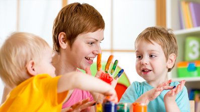 Eine Frau spielt mit zwei Kindern