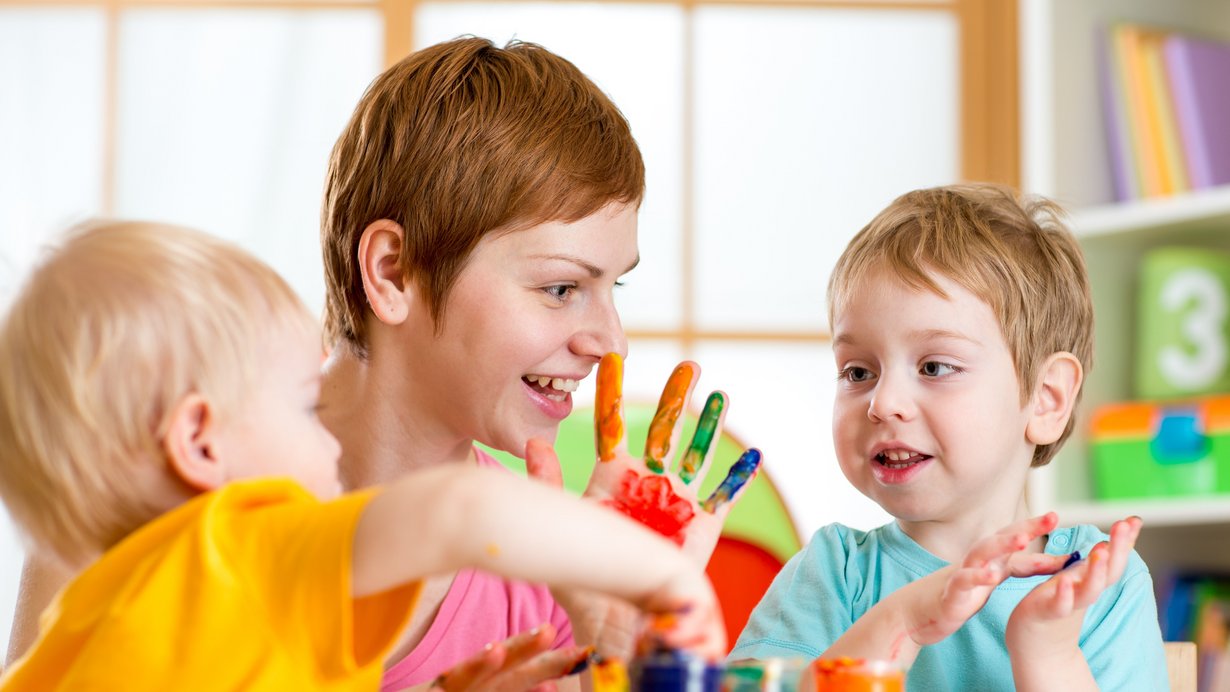 Eine Frau spielt mit zwei Kindern