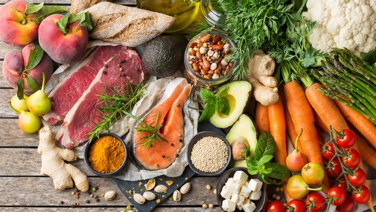 Verschiedenes Obst, Gemüse, Fisch, Fleisch und Käse liegen auf dem Tisch