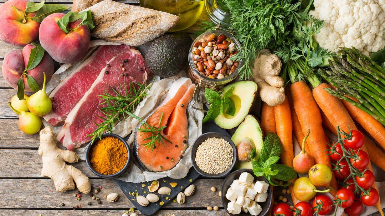 Verschiedenes Obst, Gemüse, Fisch, Fleisch und Käse liegen auf dem Tisch