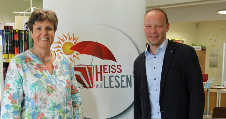Regierungspräsidentin Felder und Bürgermeister Geider eröffnen die Aktion HEISS AUF LESEN©; im Hintergrund eine Tafel mit dem Logo "Heiss auf Lesen"