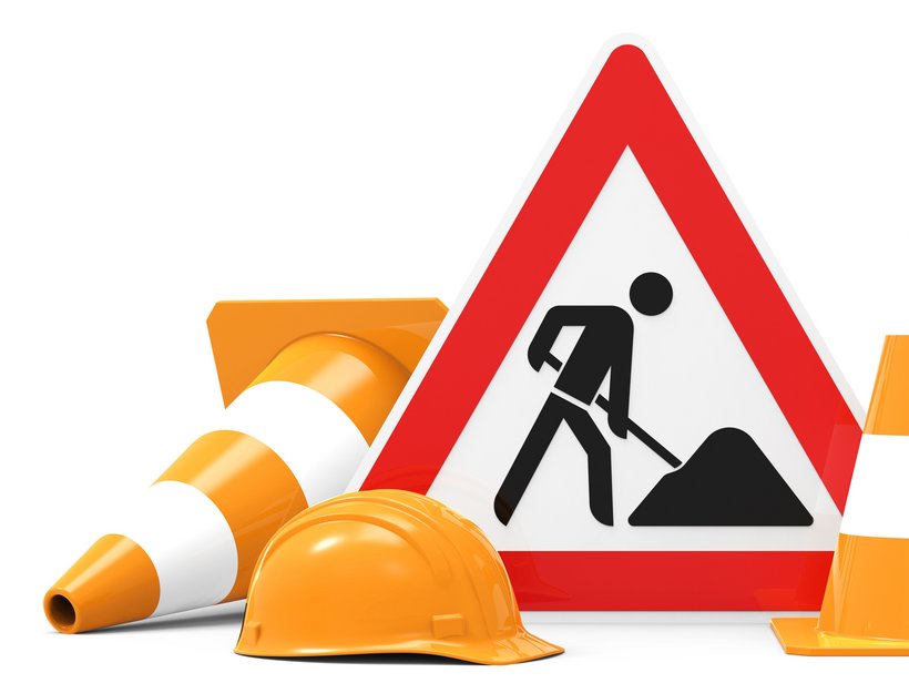 Baustellenschild, Baustellenhelm und zwei Pylonen