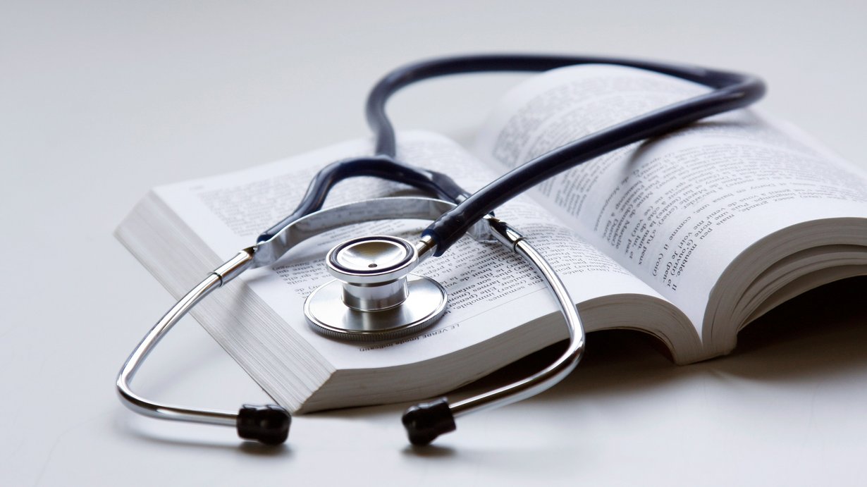 Bild zeigt Stethoskop auf einem medizinischen Lehrbuch liegend