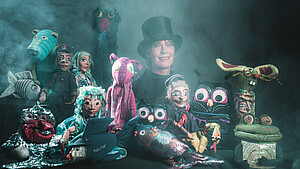 Bild zeigt Marionetten und eine Puppenspielerin