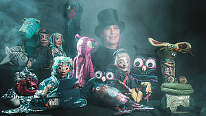 Bild zeigt Marionetten und eine Puppenspielerin