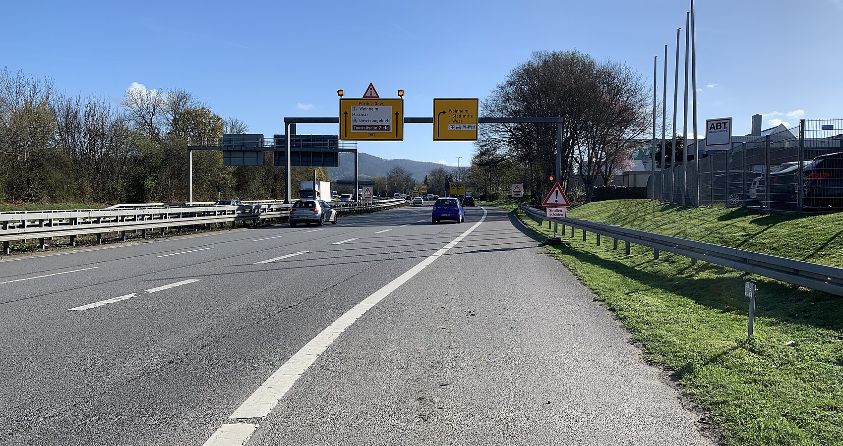 Das Bild zeigt den Blick vom Fahrbahnrand auf die Bundesstraße 38 in Fahrtrichtung Fürth/ Odenwald. Es fahren Autos auf mehreren Fahrstreifen in beide Richtungen.