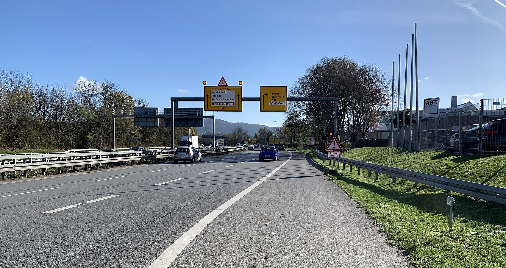 Das Bild zeigt den Blick vom Fahrbahnrand auf die Bundesstraße 38 in Fahrtrichtung Fürth/ Odenwald. Es fahren Autos auf mehreren Fahrstreifen in beide Richtungen.