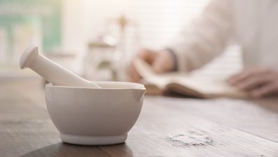 Apotheker mahlt ein Präparat mit einem Mörser