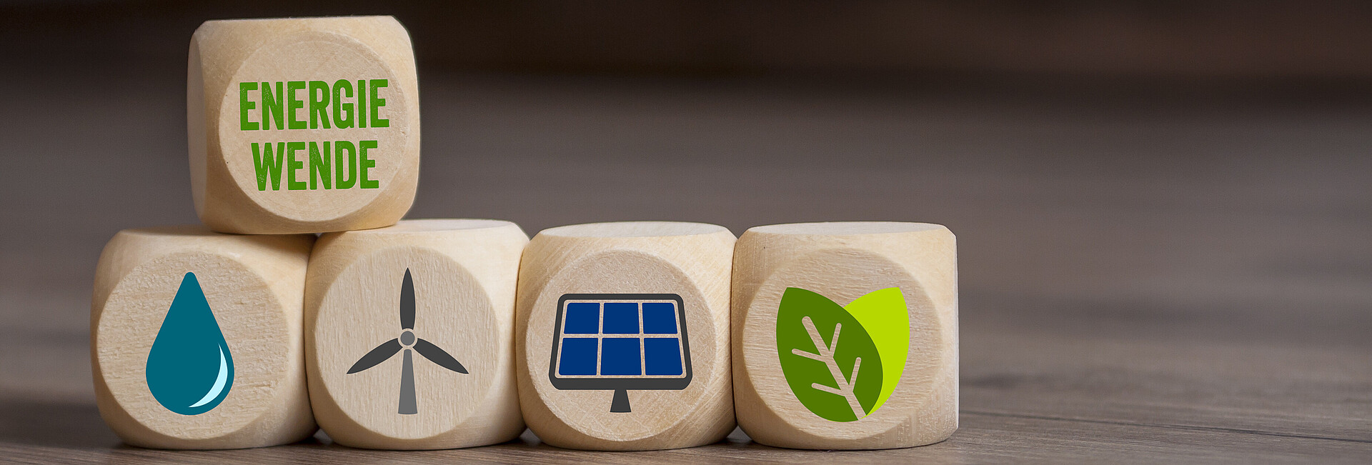 Symbolbild Energiewende; verschiedene Würfel liegen auf dem Tisch und zeigen Symbole für Windktaft, Wasserkraft, Solarenergie, Erdwärme und Biomasse